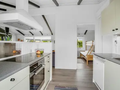 a kitchen with white cabinets and a counter top at Holiday Home Gerlis - 75m from the sea by Interhome in Torsted