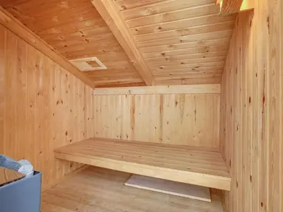 a wooden sauna with a bench in the corner at Holiday Home Gerlis - 75m from the sea by Interhome in Torsted