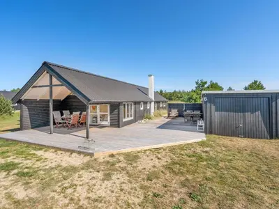 a house with a deck and a building at Holiday Home Tameran - 700m from the sea by Interhome in Torsted
