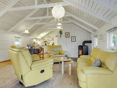 a living room with yellow chairs and a table at Holiday Home Tameran - 700m from the sea by Interhome in Torsted