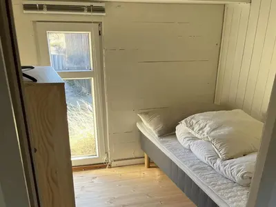 a small bed in a room with a window at Holiday Home Tameran - 700m from the sea by Interhome in Torsted