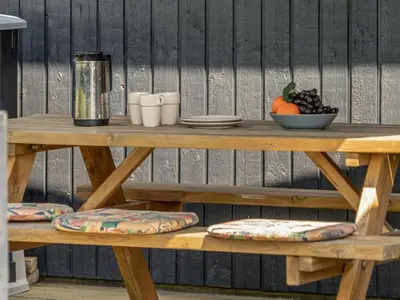a wooden table with a bowl of fruit on it at Holiday Home Chumani - 900m from the sea by Interhome in Torsted