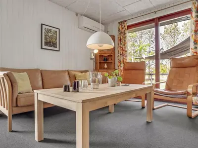 a living room with a table and a couch at Holiday Home Chumani - 900m from the sea by Interhome in Torsted