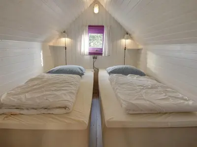 two beds in a small room with a window at Holiday Home Algonda - 500m from the sea by Interhome in Torsted