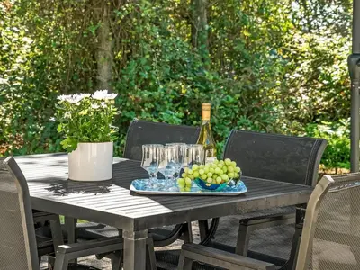 a table with a bottle of wine and a plate of grapes at Holiday Home Aslak - 350m from the sea by Interhome in Torsted