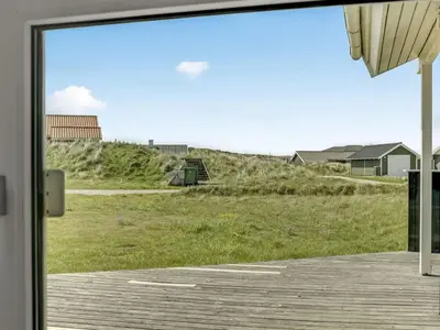 a sliding glass door with a view of a field at Holiday Home Emppu - 400m from the sea by Interhome in Torsted