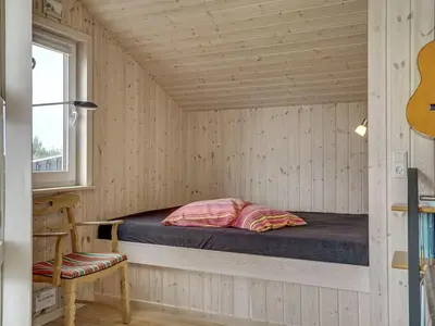 a bed in a room in a wooden house at Holiday Home Emppu - 400m from the sea by Interhome in Torsted