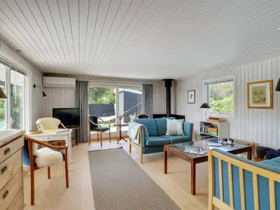 a living room with a blue couch and a table at Holiday Home Vuokko - 400m from the sea by Interhome in Torsted