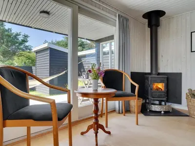 a living room with two chairs and a wood stove at Holiday Home Vuokko - 400m from the sea by Interhome in Torsted
