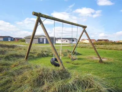 an old swing set in a field of grass at Holiday Home Gisela - 250m from the sea by Interhome in Torsted