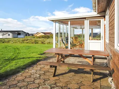 a wooden picnic table sitting outside of a house at Holiday Home Gisela - 250m from the sea by Interhome in Torsted