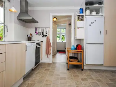 a kitchen with white cabinets and a refrigerator at Holiday Home Ludovic - 7km from the sea by Interhome in Thisted