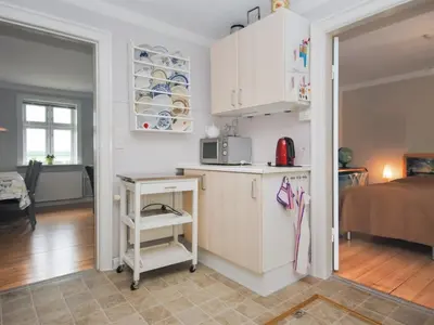 a kitchen with a table and a microwave in a room at Holiday Home Ludovic - 7km from the sea by Interhome in Thisted