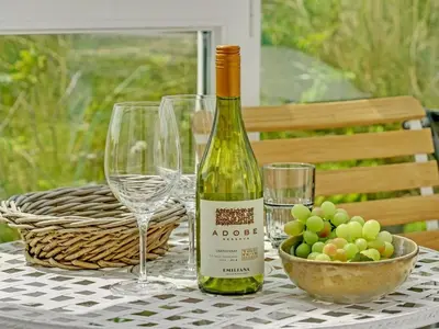 a bottle of wine sitting on a table with wine glasses at Holiday Home Quirina - 75m from the sea by Interhome in Torsted