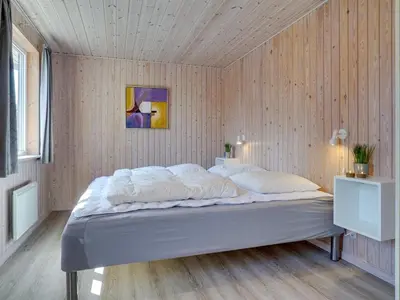 a bed in a room with a wooden wall at Holiday Home Afke - 900m from the sea by Interhome in Torsted