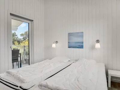 a white bed in a room with a window at Holiday Home Raakel - 950m from the sea by Interhome in Torsted