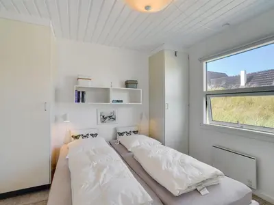 two beds in a white room with a window at Holiday Home Majgull - 150m from the sea by Interhome in Torsted