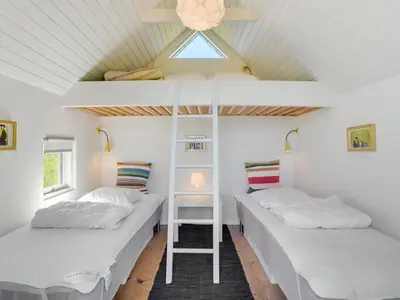 two bunk beds in a room with a roof at Holiday Home Majgull - 150m from the sea by Interhome in Torsted