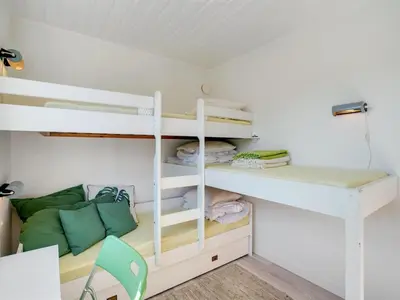a room with a bunk bed and a desk at Holiday Home Majgull - 150m from the sea by Interhome in Torsted