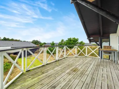 a wooden deck with a view of a field at Holiday Home Viktorija - 800m from the sea by Interhome in Torsted