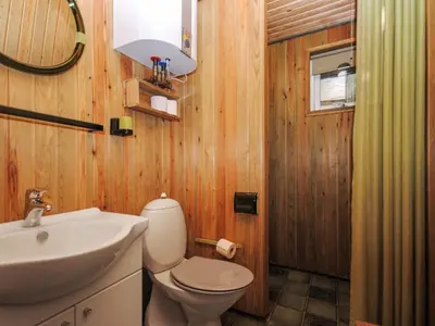 a bathroom with a white toilet and a sink at Holiday Home Tuovi - 800m from the sea by Interhome in Torsted