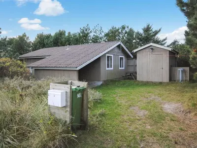 a small house with a green appliance in a yard at Holiday Home Tuovi - 800m from the sea by Interhome in Torsted