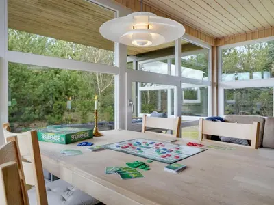 a dining room with a table and some windows at Holiday Home Asmir - 1-1km from the sea by Interhome in Torsted