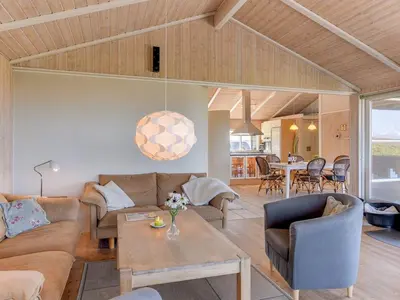 a living room with a couch and a table at Holiday Home Rink - 150m from the sea by Interhome in Torsted