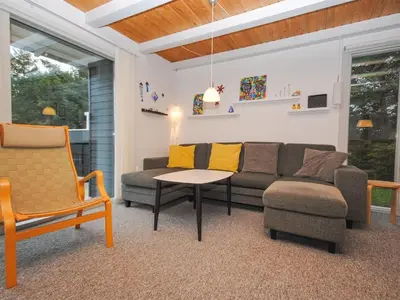 a living room with a couch and a chair at Holiday Home Amber - 500m from the sea by Interhome in Torsted