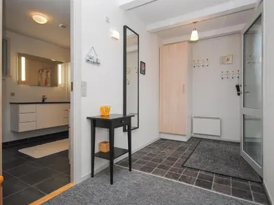 a hallway with a black table and a bathroom at Holiday Home Amber - 500m from the sea by Interhome in Torsted