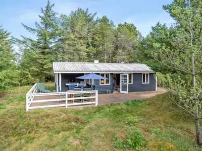a blue tiny house with a porch and a deck at Holiday Home Pilvi - from the sea by Interhome in Torsted