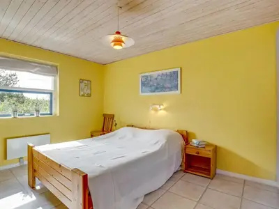 a bedroom with a bed and a yellow wall at Holiday Home Bodulf - 600m from the sea by Interhome in Torsted