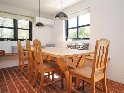 a dining room with a wooden table and chairs at Holiday Home Duco - 300m from the sea by Interhome in Torsted