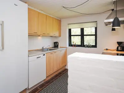 a kitchen with wooden cabinets and a white sink at Holiday Home Duco - 300m from the sea by Interhome in Torsted
