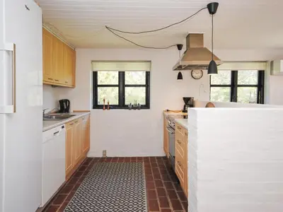 a kitchen with wooden cabinets and a counter top at Holiday Home Duco - 300m from the sea by Interhome in Torsted