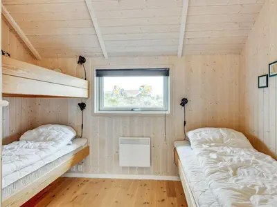 a room with two bunk beds and a window at Holiday Home Thyrger - 550m from the sea by Interhome in Torsted