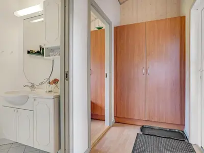 a bathroom with a sink and a mirror and a door at Holiday Home Ivar - 900m from the sea by Interhome in Torsted