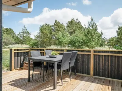 a patio with a table and chairs on a wooden deck at Holiday Home Ivar - 900m from the sea by Interhome in Torsted