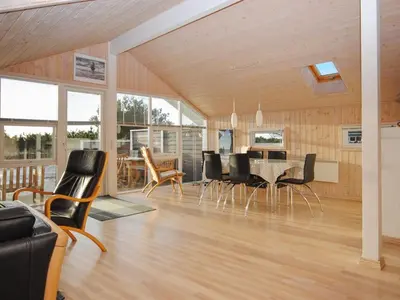 a dining room and living room with a table and chairs at Holiday Home Laurentia - 800m from the sea by Interhome in Torsted