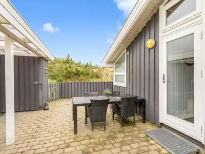 a patio with a table and chairs next to a house at Holiday Home Laurentius - 300m from the sea by Interhome in Torsted