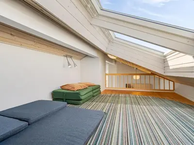 a attic room with a couch and a bed at Holiday Home Hornbogi - 300m from the sea by Interhome in Torsted