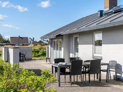 a table and chairs in front of a house at Holiday Home Hornbogi - 300m from the sea by Interhome in Torsted