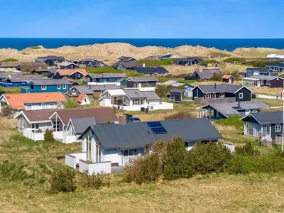 a group of houses on a hill near the ocean at Holiday Home Hornbogi - 300m from the sea by Interhome in Torsted