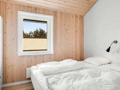 a bedroom with a bed and a window at Holiday Home Hornbogi - 300m from the sea by Interhome in Torsted