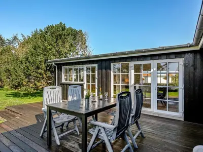 a patio with a table and chairs on a deck at Holiday Home Vivina - 250m from the sea by Interhome in Torsted