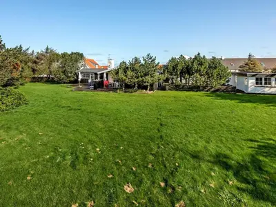 a large yard with green grass and houses at Holiday Home Vivina - 250m from the sea by Interhome in Torsted