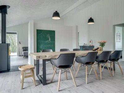a dining room with a large wooden table and chairs at Holiday Home Helli - 650m from the sea by Interhome in Torsted