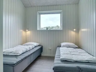 two beds sitting in a room with a window at Holiday Home Helli - 650m from the sea by Interhome in Torsted