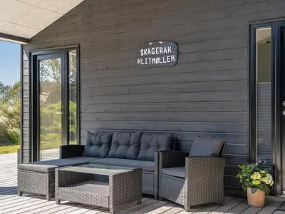 a patio with a couch and chairs on a building at Holiday Home Helli - 650m from the sea by Interhome in Torsted