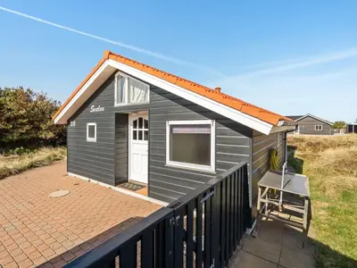 a black tiny house with an orange roof at Holiday Home Øde - 350m from the sea by Interhome in Torsted